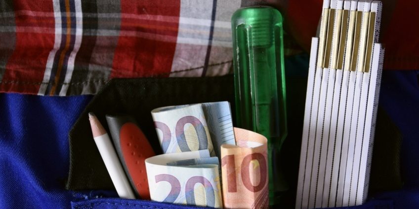 Handwerker mit Werkzeug und Geldscheinen in der Hosentasche